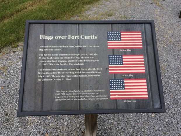 FLAGS OVER FORT CURTIS MEMORIAL PLAQUE