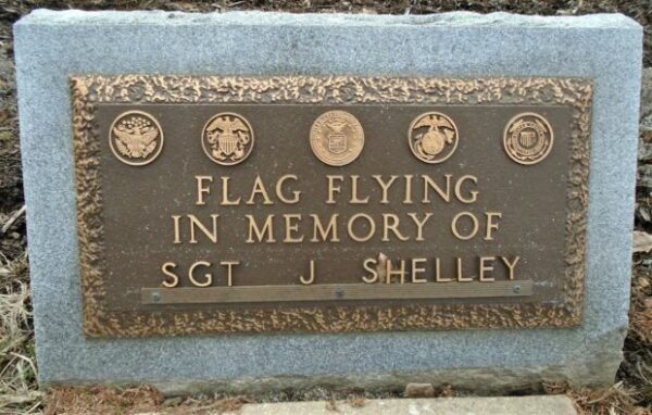 FLAG FLYING IN MEMORY OF SGT J SHELLEY MEMORIAL PLAQUE