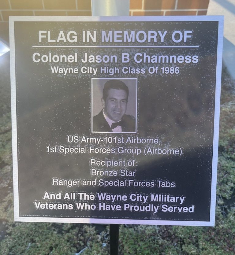 FLAG IN MEMORY OF COLONEL JASON B CHAMNESS MEMORIAL PLAQUE