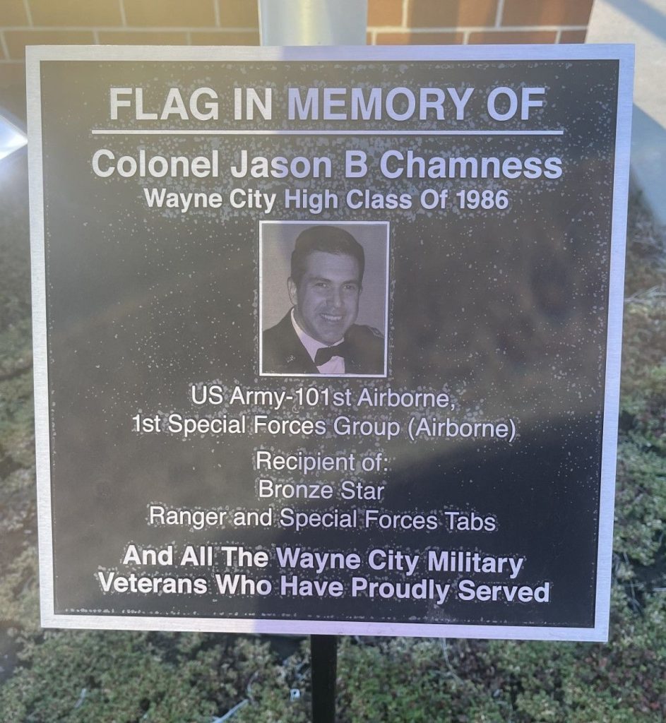 FLAG IN MEMORY OF COLONEL JASON B CHAMNESS MEMORIAL PLAQUE