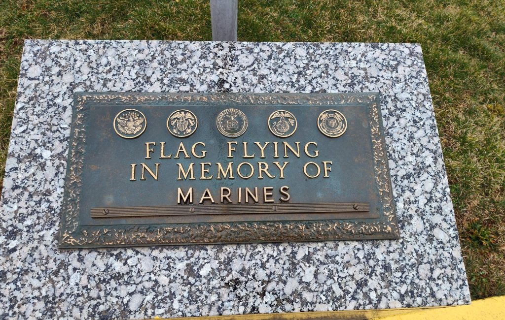 FLAG FLYING IN MEMORY OF MARINES MEMORIAL PLAQUE